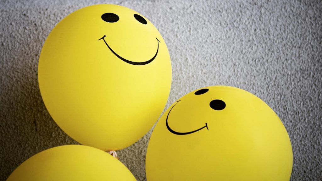 Dois balões amarelos com carinhas felizes desenhadas